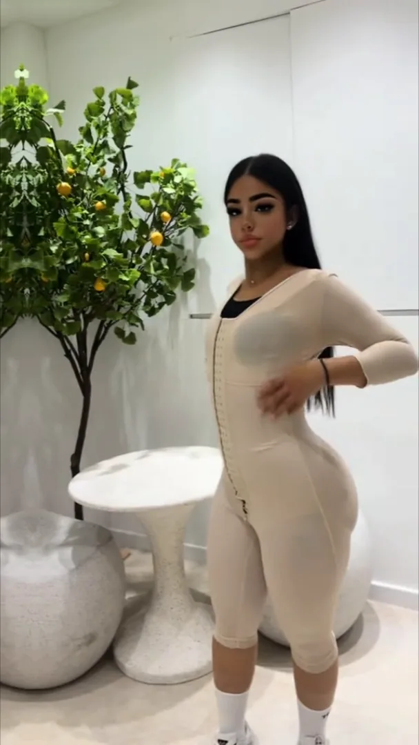 Une cliente en gaine intégrale chair dans l'espace d'essayage de la boutique, à côté du citronnier.